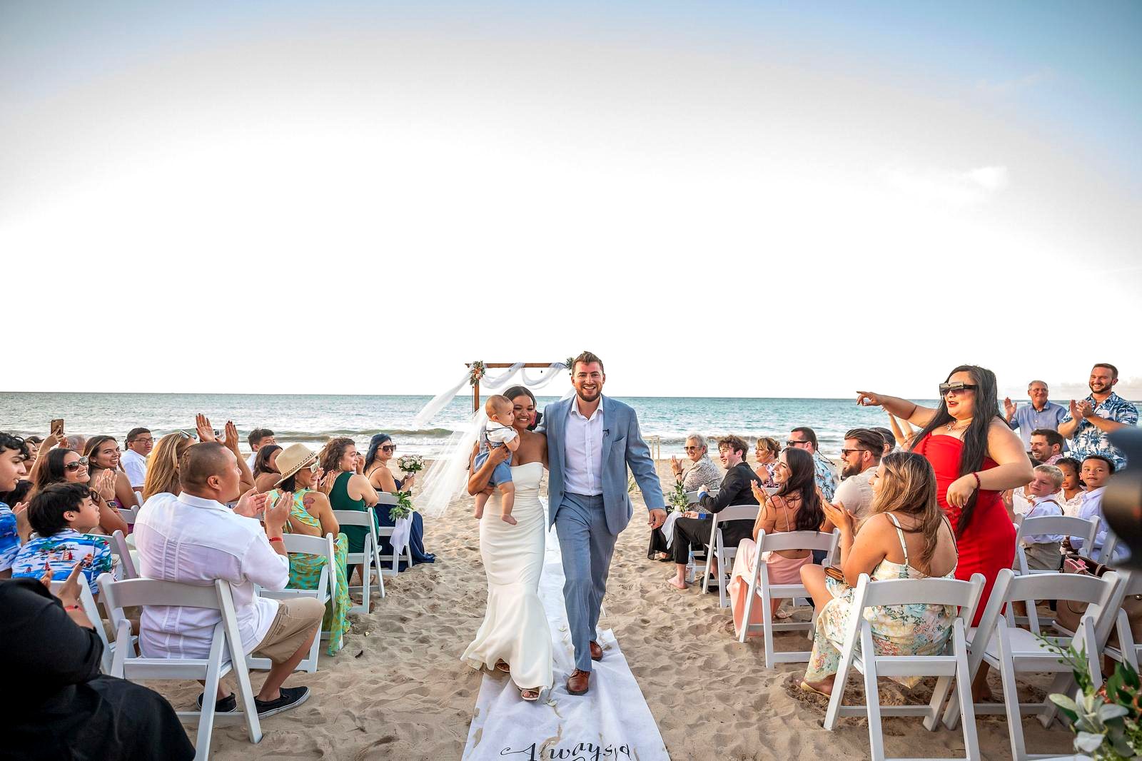 Bride and groom recessional at a beachfront multicultural wedding ceremony